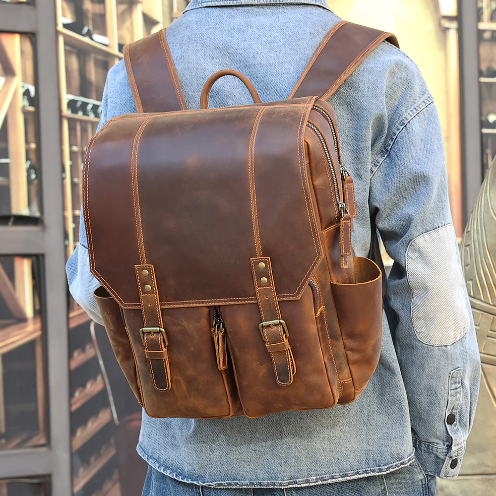 The Compact leather backpack worn on the back in denim jacket