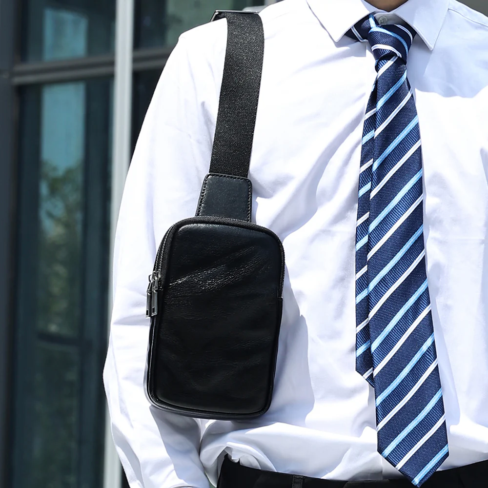 The Bellus leather sling bag worn crossbody over a shirt and tie