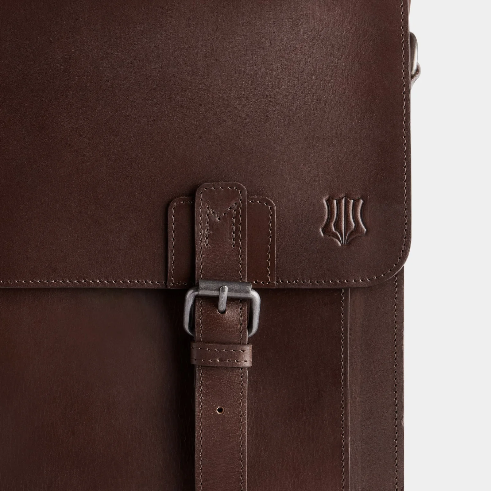 Close-up of The Heritage buckle, stitching and embossed crest