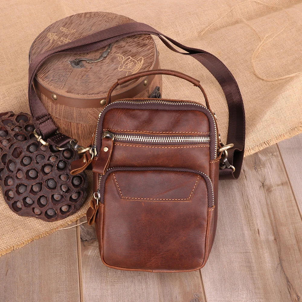 The Estro leather sling bag styled on a wooden surface